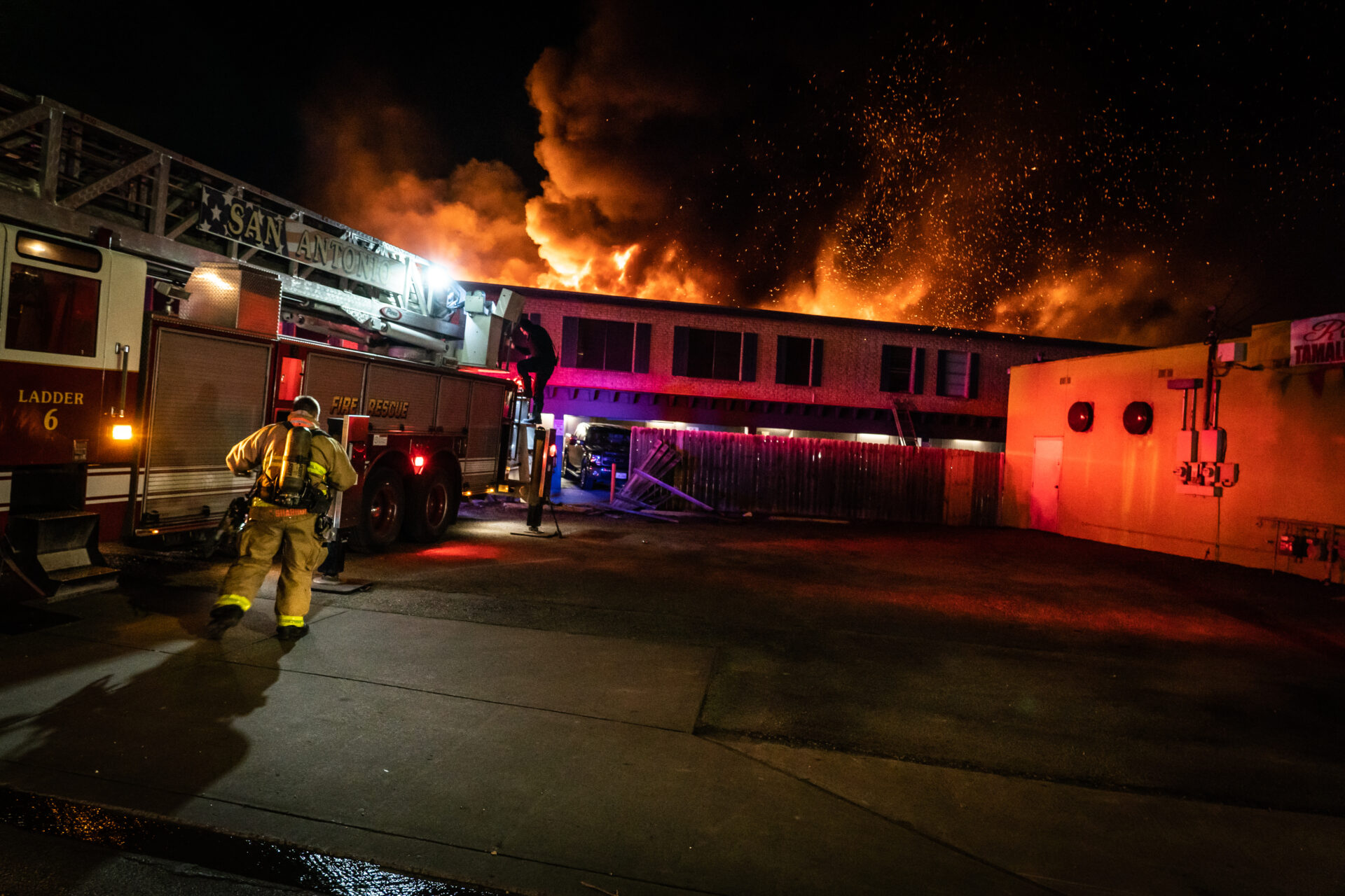 A fire fighter is standing in front of a building.